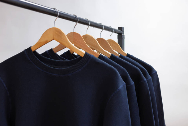 Blank sweatshirts hanging on a hanger in the wardrobe or showroom - Photo, Image
