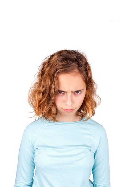 Θυμωμένος έφηβος. Όμορφη νεαρή κοπέλα με σγουρά μαλλιά θυμωμένα κοιτάζει την κάμερα - Φωτογραφία, εικόνα