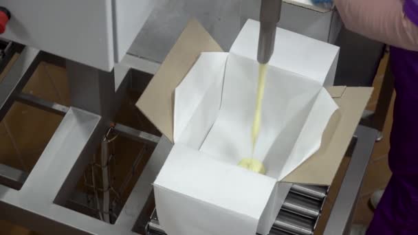 El proceso de envasado de aceite en cajas. Vista de cerca de la máquina de embalaje
 - Metraje, vídeo