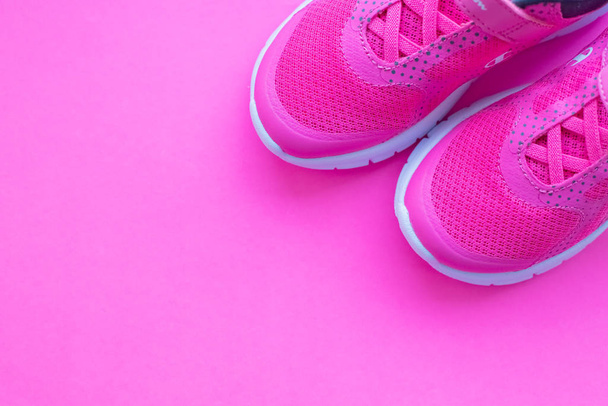 современные розовые спортивные туфли. Пара спортивных туфель на красочном фоне. Новые кроссовки на розовом фоне, копия пространства. Пара розовых тренировочных ботинок для женщин-жительниц.
 - Фото, изображение