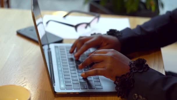 Empresária afro-americana a trabalhar com computadores portáteis e documentos. Mulher ocupada pagando contas bancárias on-line gerenciar finanças verificando orçamento fazendo papelada usando computador sentado na mesa
 - Filmagem, Vídeo