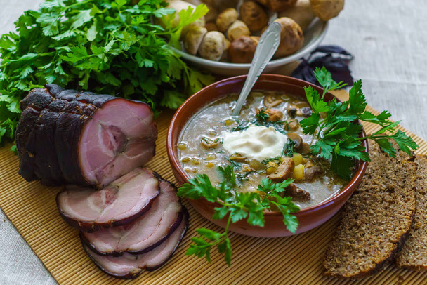 ein dörfliches Mittagessen mit Suppe mit Bohrern, dazu Sauerrahm, Roggenbrot und Grünzeug. - Foto, Bild