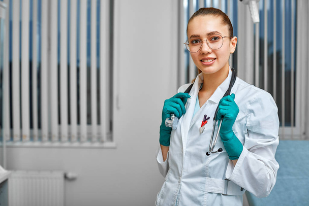 Portret szczęśliwej młodej, odnoszącej sukcesy lekarki trzymającej stetoskop. Koncepcja medyczna - Zdjęcie, obraz