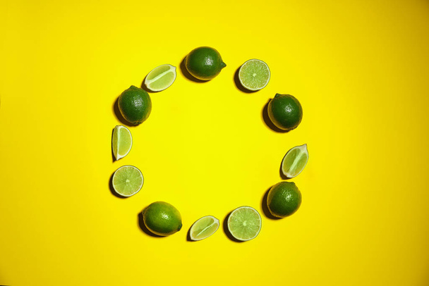 Flat lay composition with fresh juicy limes on yellow background. Space for text - Photo, image