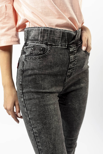 girl in jeans shows off jeans on white background close up, blue jeans - Foto, Imagem