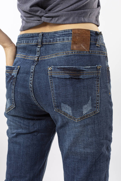 menina em jeans mostra jeans no fundo branco close up, jeans azul - Foto, Imagem