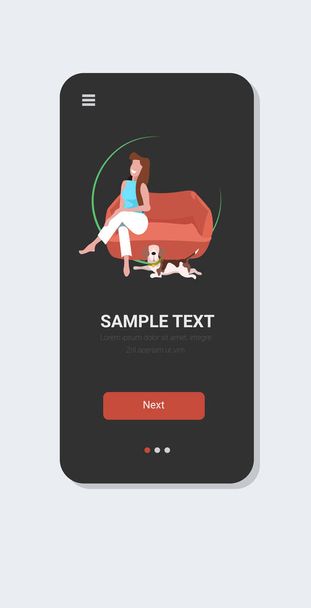 woman sitting on armchair happy girl with dog relaxing at home smartphone screen online mobile app full length vertical - Vektor, obrázek