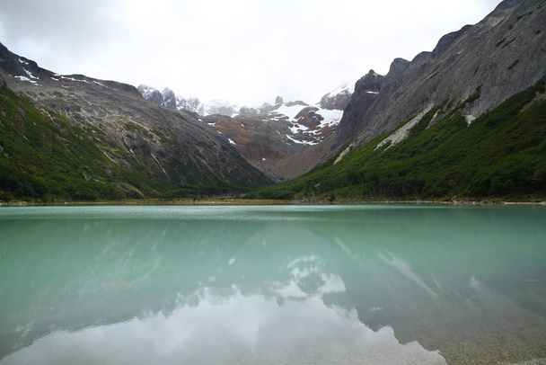 Reflecties van bergen op Laguna (Meer) Esmeralda, Ushuaia. - Foto, afbeelding