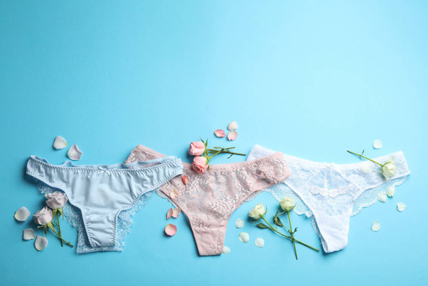 Set of elegant women's underwear and flowers on light blue background, flat lay - Φωτογραφία, εικόνα