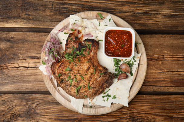 Delicious grilled pork chop served on wooden table, top view - Фото, зображення