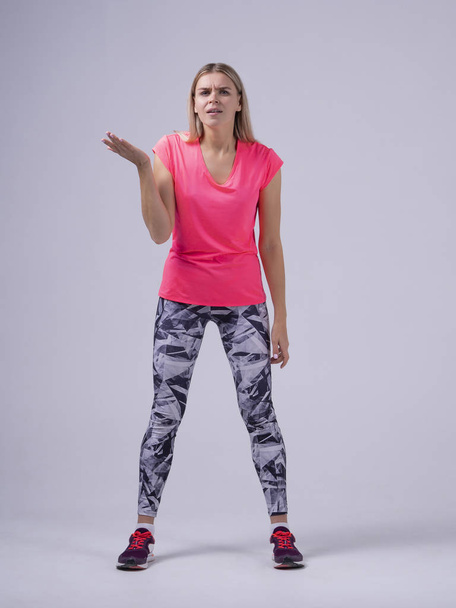 Clueless sport fit women trainer shrugging shoulders looking with confused look dont understand - Photo, image