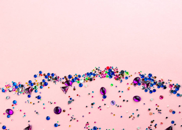 Multi gekleurde sparkly edelstenen op pastel roze achtergrond. - Foto, afbeelding