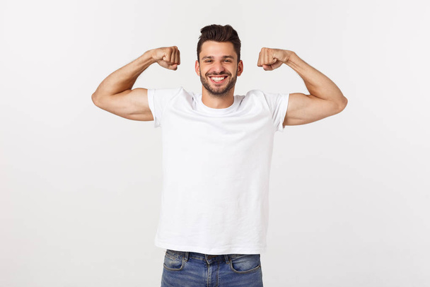 Handsome fit young funny bearded man pointing to his bicep and smiling on white background - Foto, Bild