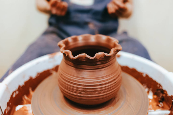 Woman potter molding clay dishes on a pottery whee - Fotó, kép