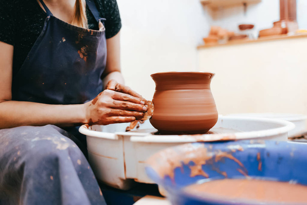 Mujer alfarero moldeando platos de arcilla en una rueda de cerámica
 - Foto, Imagen