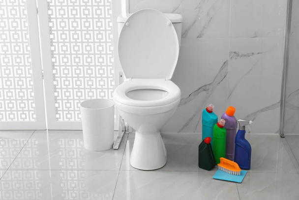 Toilet bowl and cleaning supplies in modern bathroom - Φωτογραφία, εικόνα