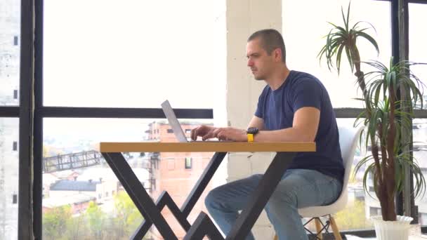 Mies työskentelee kannettavan tietokoneen toimistossa tai coworking
 - Materiaali, video