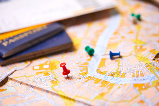 alfinetes marcando pontos de itinerário de viagem no mapa com passaportes
 - Foto, Imagem