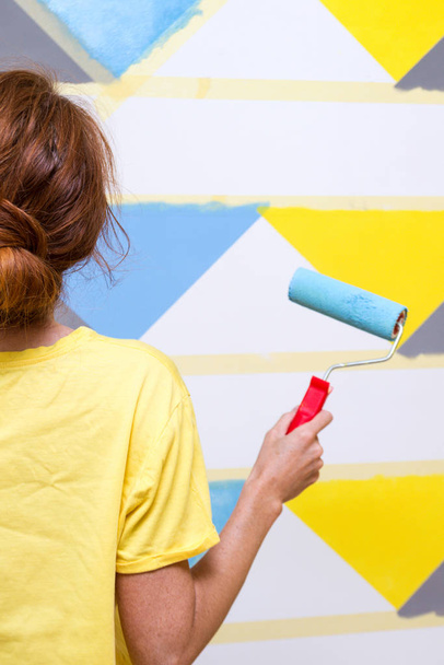 girl paints the wall  - Foto, afbeelding