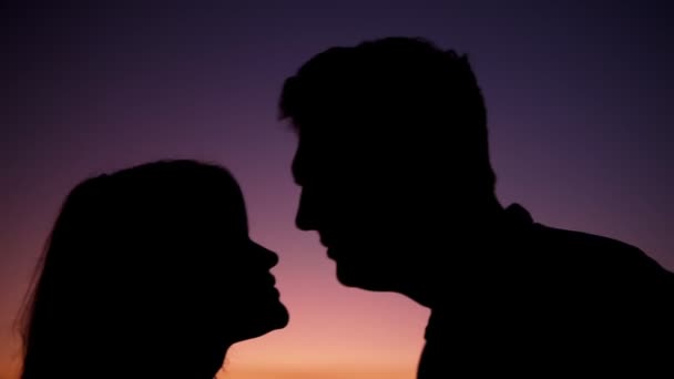Sylwetki profili głów całujących miłośników zachodu słońca - Materiał filmowy, wideo