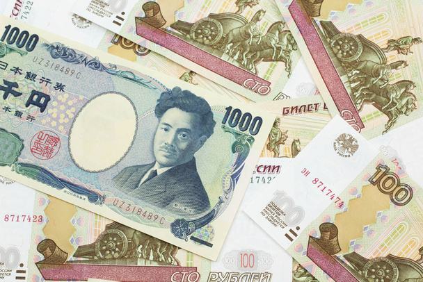 A one thousand Japanese yen bank note close up in macro with Russian one hundred ruble bills - Photo, Image