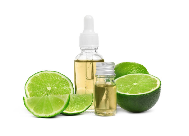 Lime essential oil in bottles and citrus fruits isolated on white - Фото, изображение