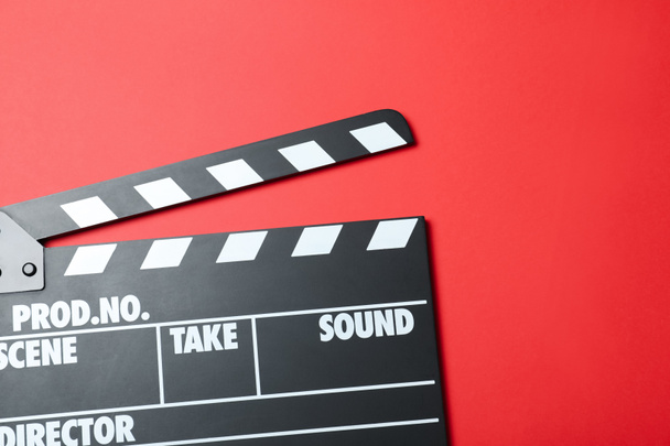 Clapper board on red background, top view. Cinema production - Foto, Imagen