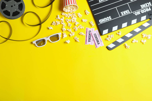 Flat lay composition with cinema tickets and clapperboard on yellow background, space for text - Фото, изображение