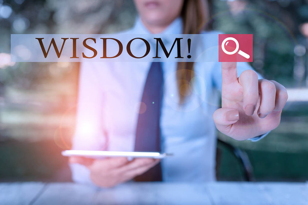 Text sign showing Wisdom. Conceptual photo quality having experience knowledge and good judgement something Female business person sitting by table holding mobile phone. - Photo, Image