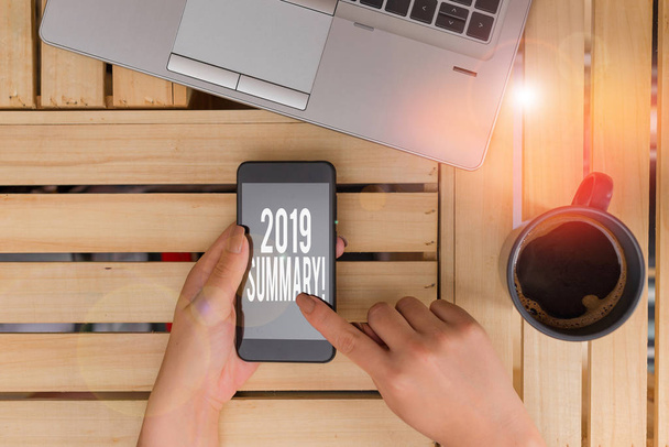 Text sign showing 2019 Summary. Conceptual photo summarizing past year events main actions or good shows woman computer smartphone drink mug office supplies technological devices. - Photo, Image