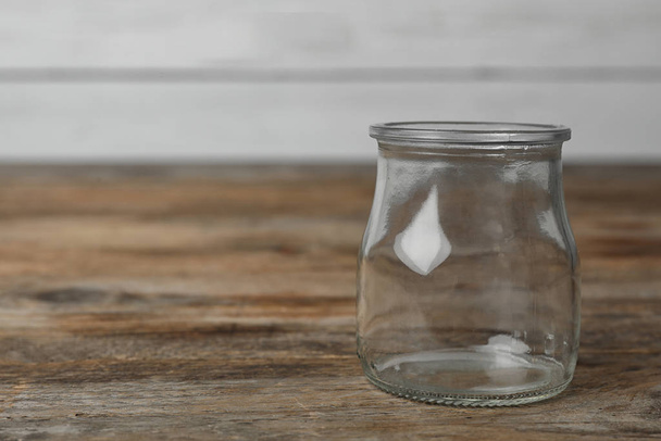 Empty glass jar on wooden table, space for text - Foto, imagen