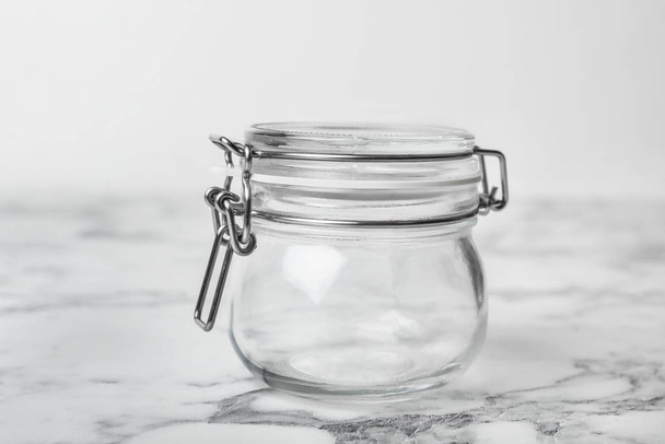 Empty glass jar on white marble table - Фото, изображение