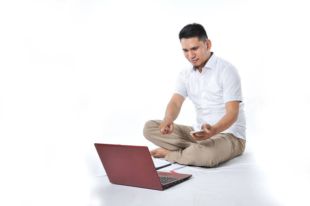 Retrato de empresário asiático sentado no chão branco e chamando
  - Foto, Imagem
