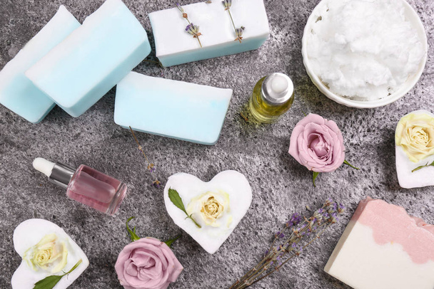 Flat lay composition with natural handmade soap and ingredients on grey stone table - Фото, зображення