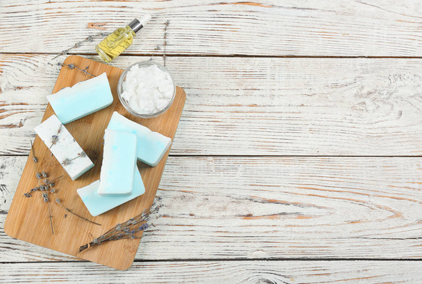 Flat lay composition with natural handmade soap and ingredients on white wooden table, space for text - Foto, Imagen