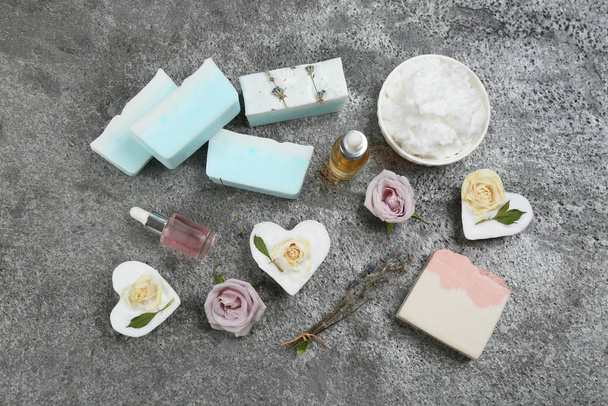 Plochá kompozice s přírodním ručně vyrobeným mýdlem a ingrediencemi na šedém kamenném stole - Fotografie, Obrázek
