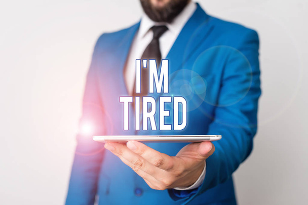 Conceptual hand writing showing I M Tired. Business photo text drained of strength and energy Fatigued to the point of exhaustion Businessman in blue suite with a tie holds lap top in hands. - Photo, Image