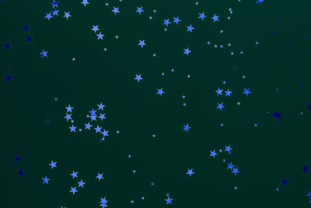 Estrellas brillantes brillan confeti sobre fondo azul. Fondo de vacaciones clásico
. - Foto, Imagen