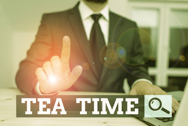 Conceptual hand writing showing Tea Time. Business photo showcasing the time in the afternoon when some showing eat a small meal Male human wear formal clothes present use hitech smartphone. - Photo, Image
