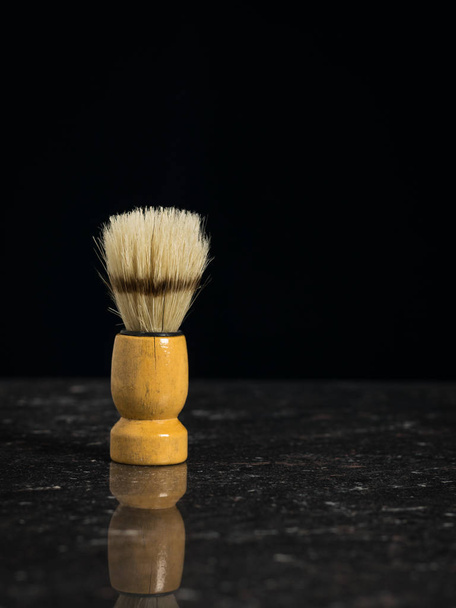 Βούρτσα ξυρίσματος Vintage για ξύρισμα στο πέτρινο τραπέζι σε μαύρο φόντο. - Φωτογραφία, εικόνα