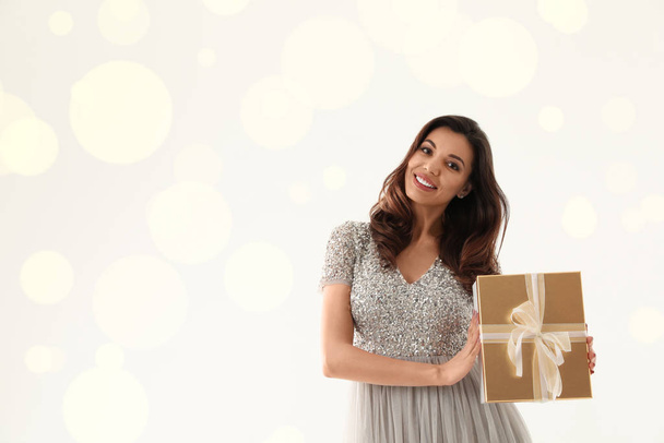 Beautiful woman with Christmas gift on white background - Fotó, kép
