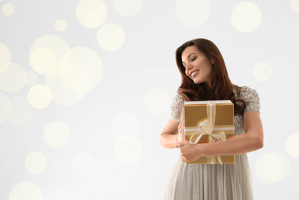 Beautiful woman with Christmas gift on white background - Photo, Image
