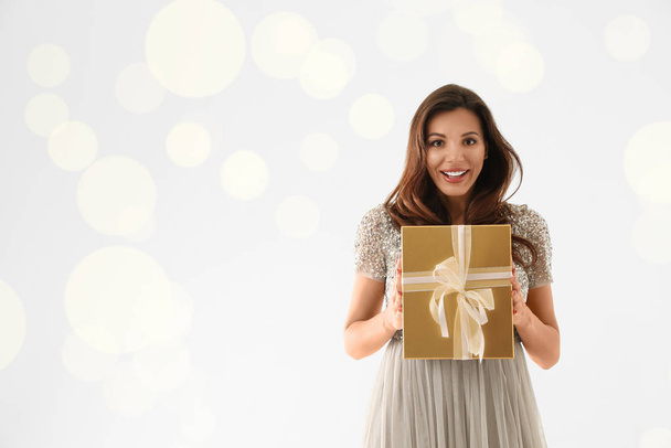 Beautiful woman with Christmas gift on white background - Valokuva, kuva