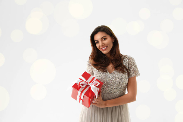 Beautiful woman with Christmas gift on white background - Photo, image