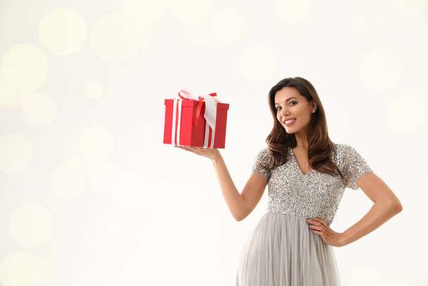 Beautiful woman with Christmas gift on white background - Фото, зображення
