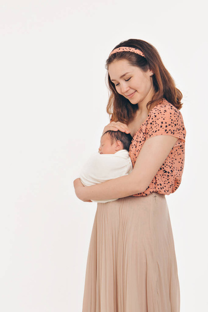 健康的なライフスタイル、子供の保護、買い物の概念-母親の腕の中で赤ちゃん。子供を持つ女性。白い背景に隔離されている。スペースのコピー - 写真・画像
