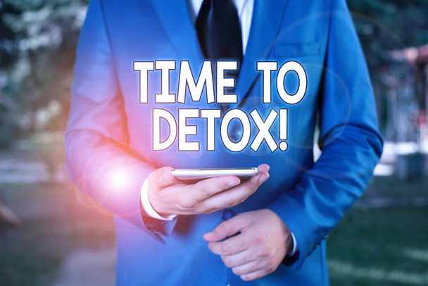 Εννοιολογική γραφή χεριών που δείχνει το Time To Detox. Επαγγελματικό κείμενο φωτογραφιών όταν καθαρίζετε το σώμα σας από τοξίνες ή να σταματήσει την κατανάλωση ναρκωτικών Επιχειρηματίας σε μπλε σουίτα στέκεται με το κινητό τηλέφωνο στα χέρια. - Φωτογραφία, εικόνα