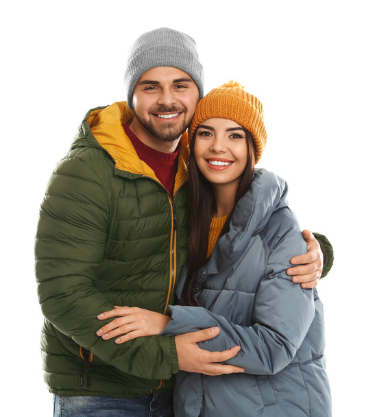 Happy young couple in warm clothes on white background. Winter vacation - Valokuva, kuva