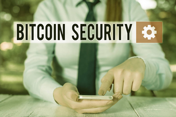 Conceptual hand writing showing Bitcoin Security. Business photo showcasing funds are locked in a public key cryptography system Female business person sitting and holding mobile phone. - Photo, Image