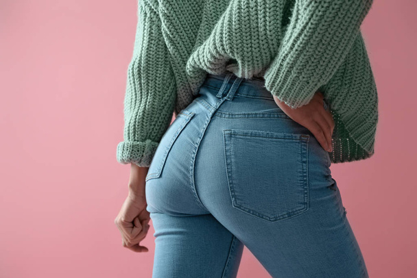 Woman wearing jeans on pink background, closeup - Foto, immagini